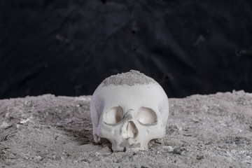 human skull in ash on a black background, halloween