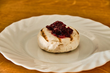 Grilled blue cheese with marmalade on white plate