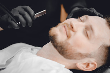 Obraz na płótnie Canvas Barbershop. Hairdressers barber hair and beard with razor in salon