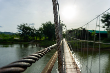 Wire rail wooden bridge over the river.