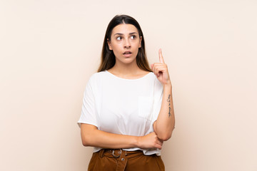 Obraz premium Young brunette woman over isolated background thinking an idea pointing the finger up