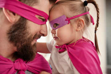 Close up of father and daughter in superhero and superwoman costume