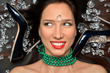 Portrait of a luxurious brunette girl lies in a placer of diamonds jewelry, luxury accessories