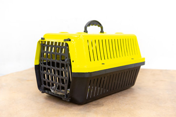 Close up of plastic pet carrier for transporting dogs and cats on wooden table isolated on white background. Pet care concept. Selective focus.