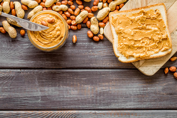 peanut butter for cooking breakfast with sandwiches at home on wooden background top view mock-up