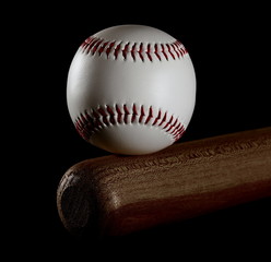 Baseball and wooden bat isolated on black background