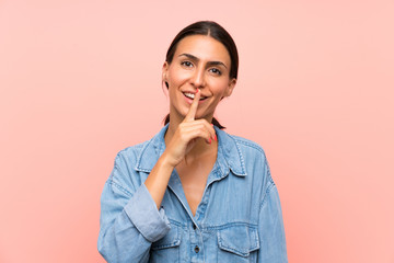 Young woman over isolated pink background doing silence gesture