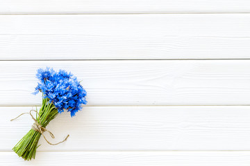 Summer design for blog with bouquet of blue cornflowers on white wooden background top view copyspace
