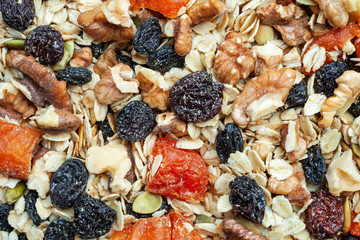 Organic homemade Granola with oats, nuts and dried fruits. Texture oatmeal granola or muesli as background. Fitness breakfast. Healthy food. Top view. Close up