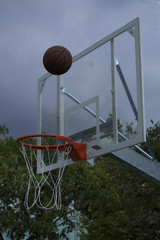 basketball hoop and net against cloudy and rainy sky