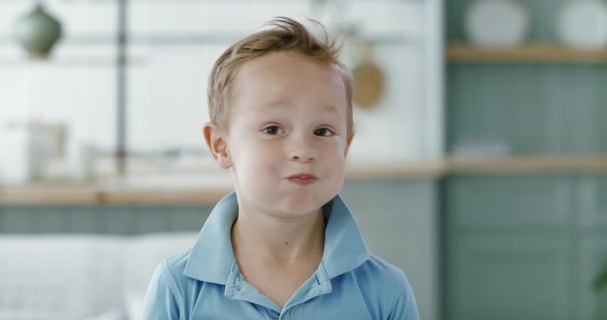FIXED Portrait of little cute Caucasian kid boy doing silly funny face, looking into camera. 60 FPS Slow Motion, 4K RAW graded footage