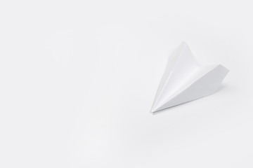 Flat lay of white paper airplane and blank paper on white background.