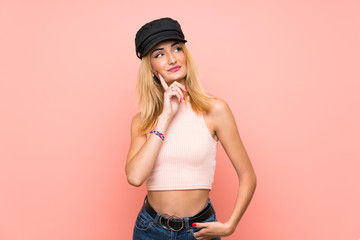 Young blonde woman with hat thinking an idea while looking up