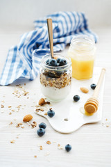 Healthy breakfast in glass jar with yogurt, muesli and blueberries. Healthy food.