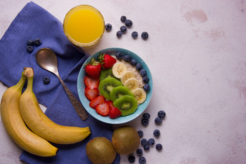 Oatmeal porridge with blueberries, strawberry, banana and kiwi in bowl