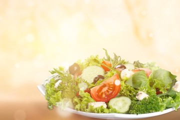 Individual side serving of delicious fresh Greek salad with feta cheese, olives, tomatoes and salad greens