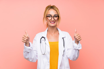 Young blonde doctor woman giving a thumbs up gesture