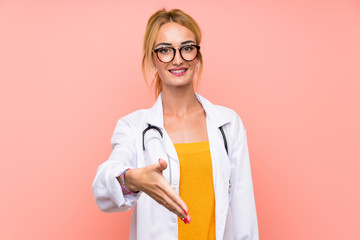 Young blonde doctor woman handshaking after good deal