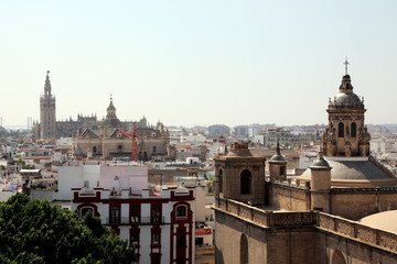 Fototapeta premium Seville / Spain – September 15 2018: A view across the rooftops of Seville, with Seville Cathedral in the distance