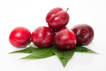 plums with plum leaves isolated on a white background