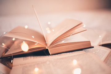 Open book with magic Christmas lights closeup. Good morning. Night time.