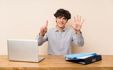 Young student man with a laptop counting six with fingers