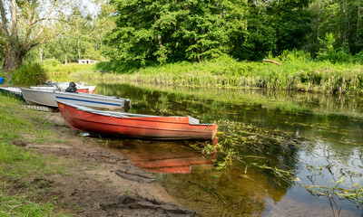 beautiful and bright boat on the banks of Seda river, beautiful reflections, Latvia