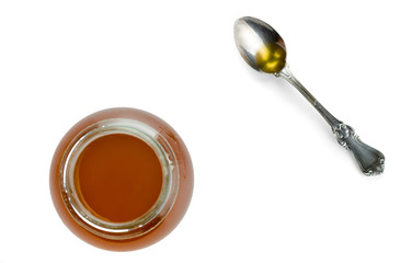 Round glass jar and spoon with freshly prepared ghee isolated on white background. View from above.