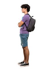 Fototapeta premium A full-length shot of a Young student man in lateral position over isolated white background
