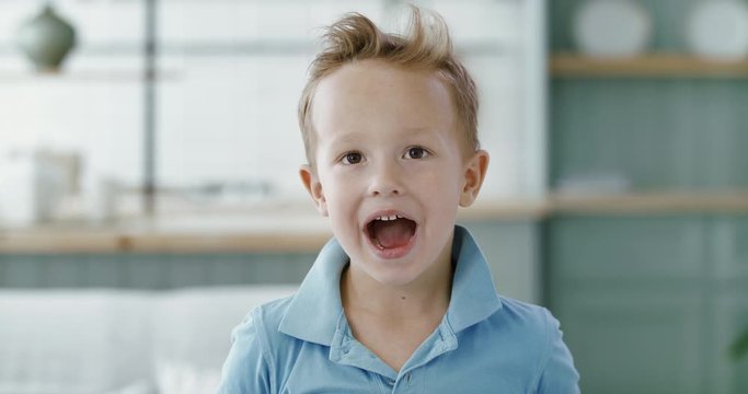 FIXED Portrait of little cute Caucasian kid boy doing silly funny face, looking into camera. 60 FPS Slow Motion, 4K RAW graded footage