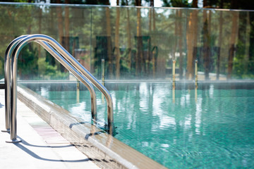 transparent swimming pool with railings on resort during daytime