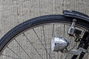 Schwarzer Fahrradreifen mit silbernem Halogenstrahler als Fahrradlampe und Dynamo und grauem...