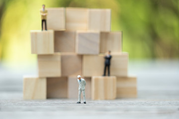 Miniature people: Confident business men on jigsaw puzzle icon, success, dealing, greeting and partner concept.