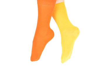 Yellow and orange socks on woman foot isolated on white background.