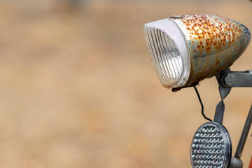 Alte rostige Fahrradlampe mit Frontreflektor vor schönem unscharfen Hindlampe mit Frontreflektor...
