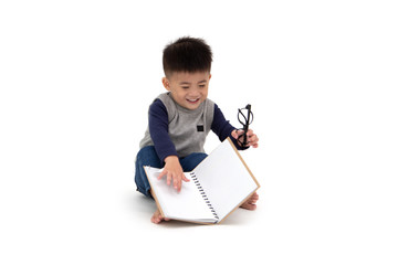 Portrait of a cute Asian little boy sitting on floor and reading a book isolated over white background, Back to school concept, 1 year 10 month old