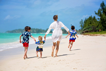 Mother and child playing at tropical beach. Family sea summer vacation. Mom and kid, toddler boy,...