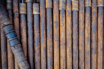 Oil Drill pipe. Rusty drill pipes were drilled in the well section. Downhole drilling rig. Laying the pipe on the deck. View of the shell of drill pipes laid in courtyard of the oil and gas warehouse