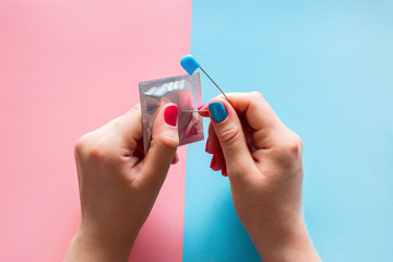 a woman pierces a condom with a pin
