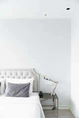 Cozy bedroom corner in minimal modern style with empty cool gray painted wall in the background / in terior concept / background for advertising.