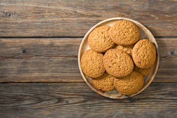 Oatmeal cookies in a wooden plate on a wooden table. rustic style