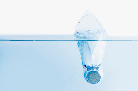 Euro coins sinking in water as a symbol of global economic crisis and downturn of Europe.