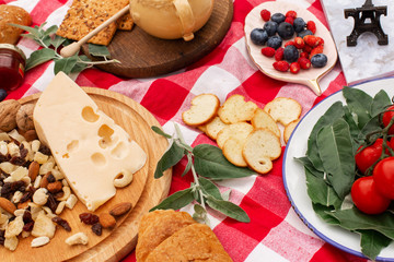 Stylish picnic on the green lawn. Fresh croissants and a teapot with tea on a bedspread near a wicker female hat. Instagram content