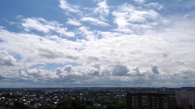 White clouds forming over city, summer day-time. Skyscape timelaps.