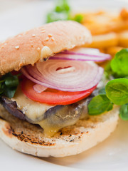 American style Vegan Portobello Chestnut Mushroom Burger served with tomato,onion, fries and green, fresh salad.