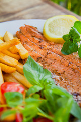 Deep fried wild trout fish served with potato chips fries and fresh salad.