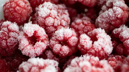 Background of frozen raspberries. Ripe raspberries with frosty freshness.