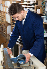 Man processing plank at workshop