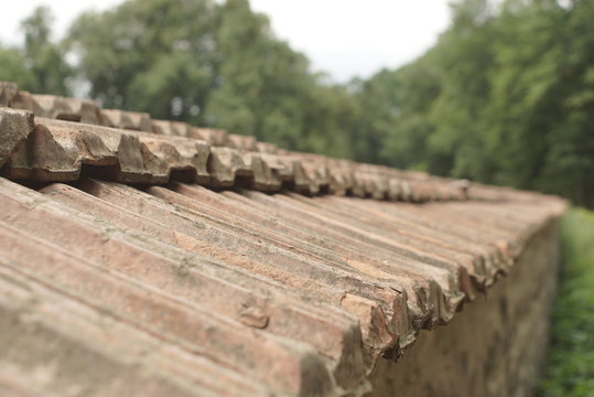 Close-up image of weathered brown tiles on roof 