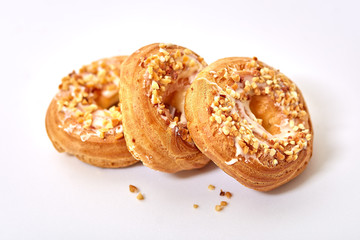 Chocolate and powdered sugar cream puff rings, choux pastry.On white background.
